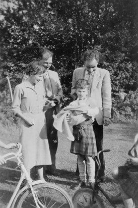 Andrew being held by his cousin Michael, while his parents (left) and Uncle John look on (1956)