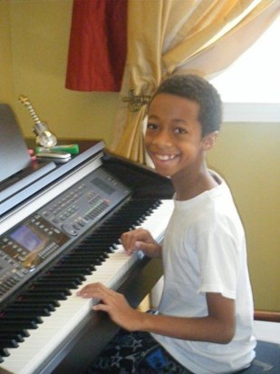 Trying to teach himself how to play the piano.... all smiles... 