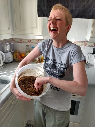 Laughing at a dirty Santa joke, whilst stirring the Christmas pudding.