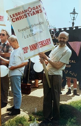 John holding a banner at the 20th anniversary on the Lesbian and Gay Christian Movement