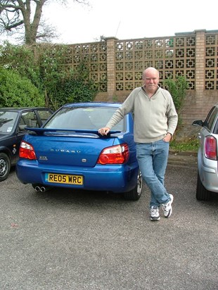 Proudly next to one of his cars