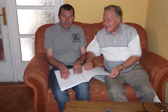 Gezim with Mike, reading braille on a trip to Romania 