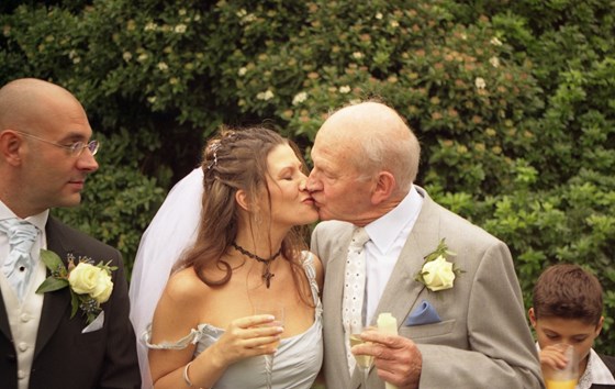 05 Dad sneaking a kiss at his sons wedding