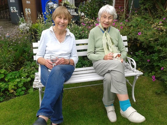 Mary and Rita on the old white bench in the garden 