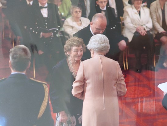 May receiving her MBE from the Queen 