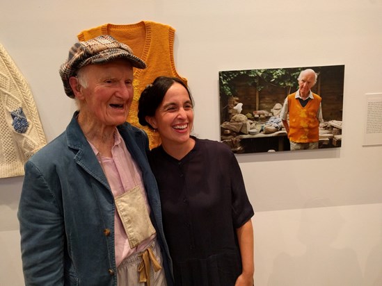 Bill with Celia and his yellow jumper in front of his outdoor sculpture studio