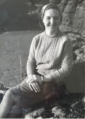 Mum sitting on a rock at Rest Bay in her early teens