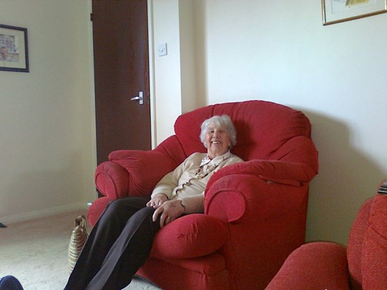 Grandma looking happy enveloped in the red armchair at 5 Keith Close