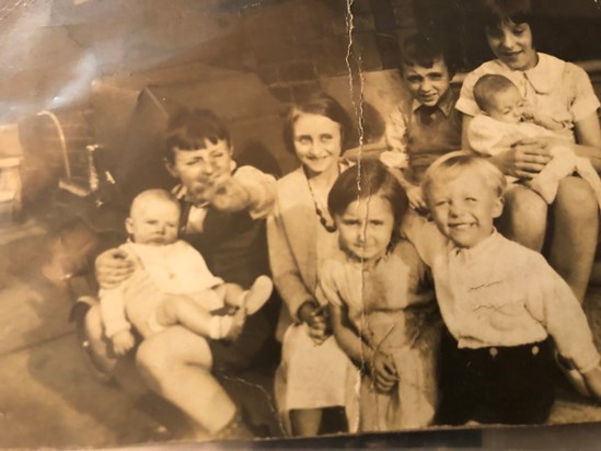 Josie in the middle, being hugged by her cousin Bill, surrounded with her sisters, brothers and more cousins.