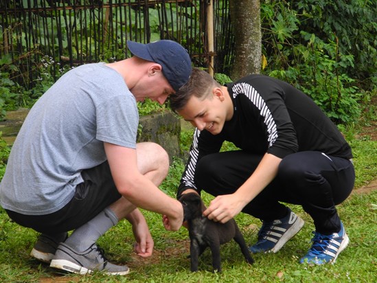 Raz and Scott petting a dog in Vietnam