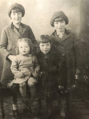 Tom is the child on the lap of his older sister Joyce, with his other sisters Sylvia and Gwen