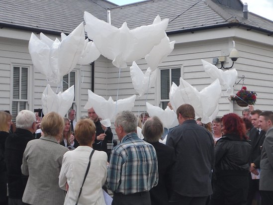 Dove balloons being released at Mums service