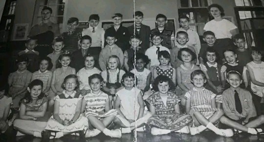 Lynda, on left with arms folded - Middle Row School about 1959