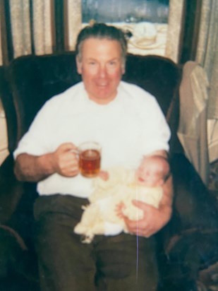 A cuddle with his first grandchild and a pint! 