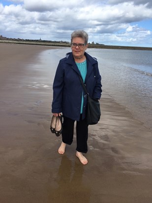 My beautiful mum enjoying a paddle in the sea. She looks so happy. 