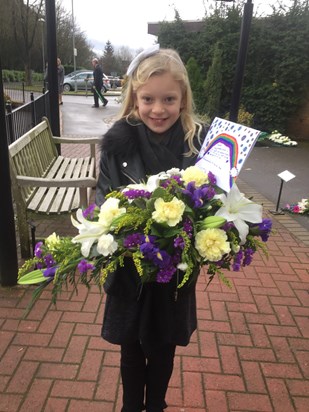 Grace with Grandad's flowers and the card she made for him.