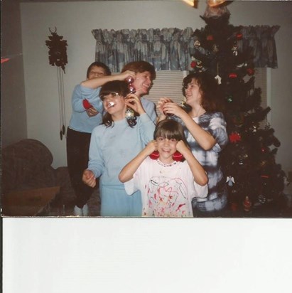Shana (on the right) with me and her siblings being silly while decorating the Christmas tree