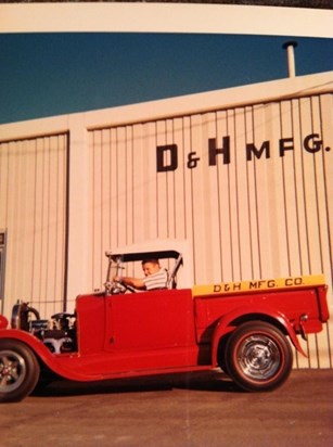 Don in red roadster in front of father's machine shop