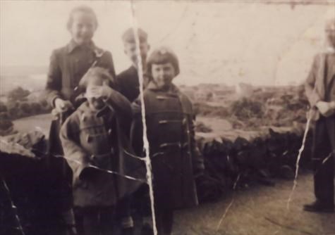 Pete with 3 of his sisters and Dad hiding in Ramsey1959