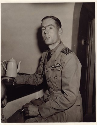 Leonard Cheshire in uniform with cup of tea and cigarette