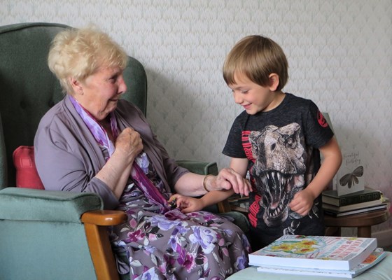 Great-grandson Piran teases his great-grandmother with a wind-up toy spider - August 2015