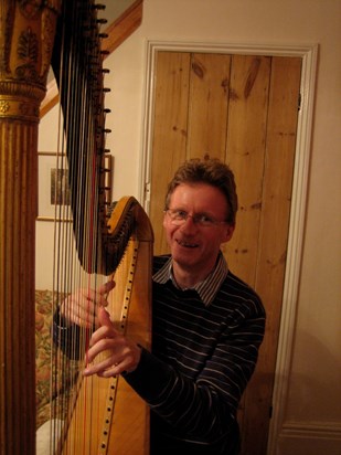 Gwil playing a Harp. 