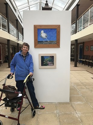 Mum standing next to her painting called ‘Seagull with Attitude’  
