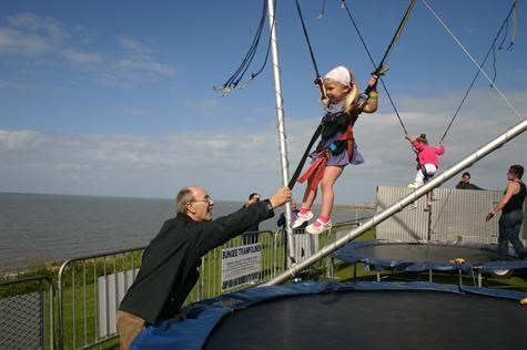 Grandad giving Annabelle a turn on the Bungee trampoline at Tankerton seafront on Fathers Day 2010