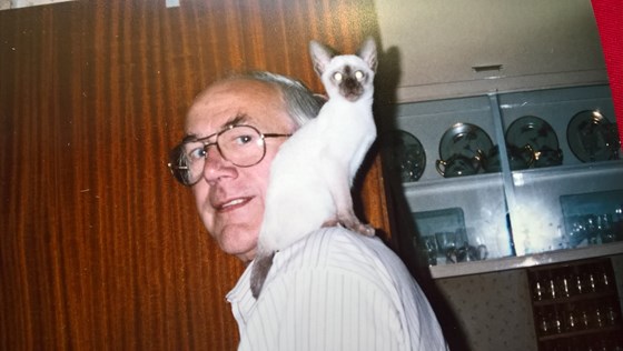 Trevor with one of their Siamese cats