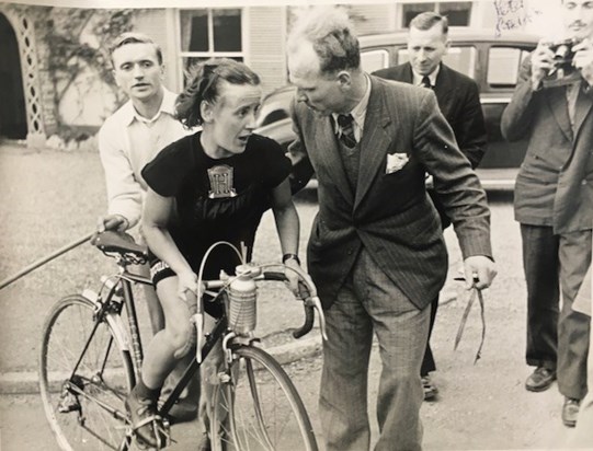 E S, on a hard record breaking ride, with one of the Hercules team Maurice Tugwell holding her saddle