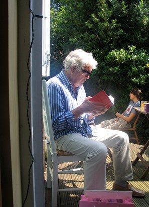 Brian reading in Lisa’s garden, with grandson Jason in the background