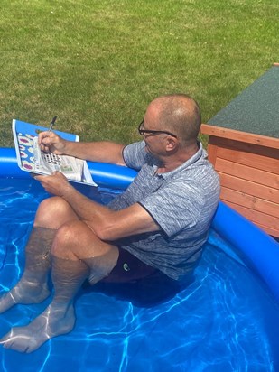 Dave relaxing at work. It was a hot day so what better way to relax than sit in a paddling pool and do the crossword. 