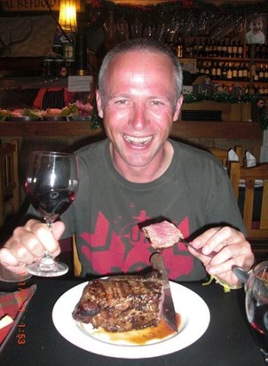 Paul eating steak and drinking wine