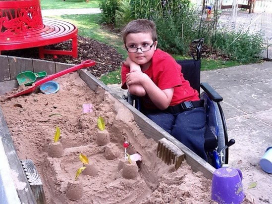 Zak playing in sandpit at Helen House