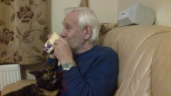 Dad at my house with Amy the cat on his lap again enjoying a cup of coffee.