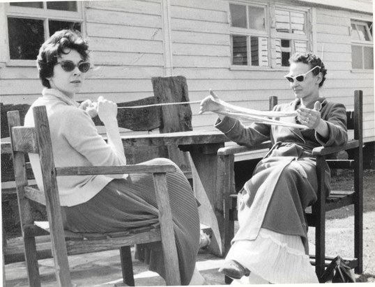 Gay winding wool, Anne holding the skein for her. Clapboards of the bungalow Anngay in Surrey.