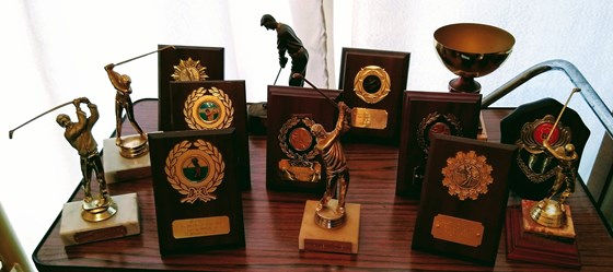 Some of dad's golfing trophies including one for a hole in one