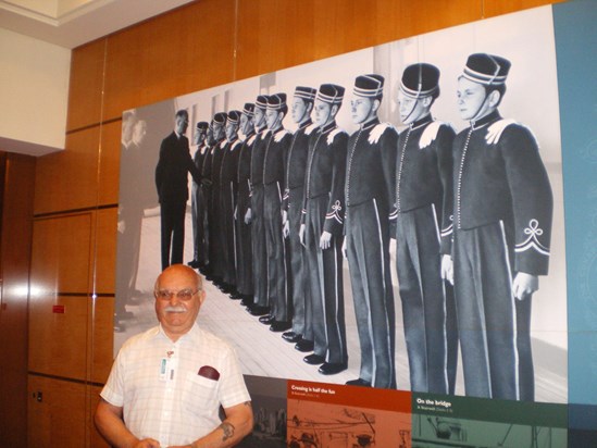 2009 Dad on QM2  next to his picture on the ship