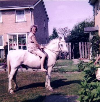 Sheila on Yvonne's pony, Smokey in garden of 26, Navigator's Way