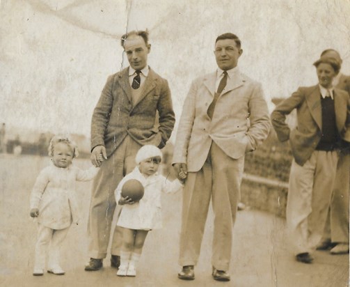 Peter (with the ball and bare legs) and his cousin June (on the left) with their dads.