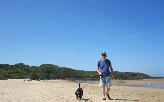 Bob walking his dog Jessie on the beach in Anglesey
