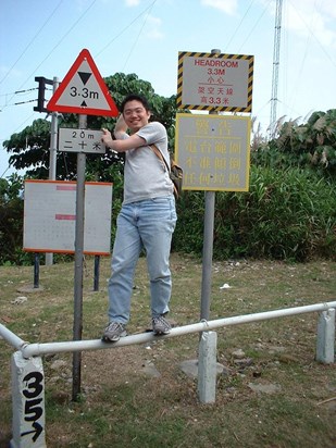 Simon with signposts and radio masts closeby.