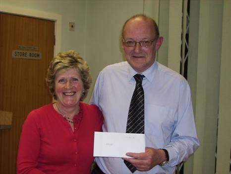 Christine presents her cheque raised for Janice in memory of Ian