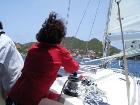 Carol winching the sail in the Caribbean