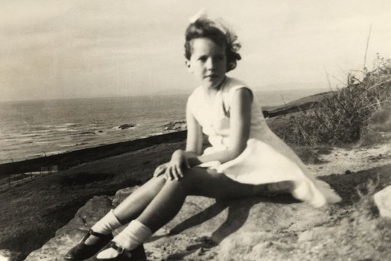 Jo sitting on the edge of the beach, Heysham, c1954