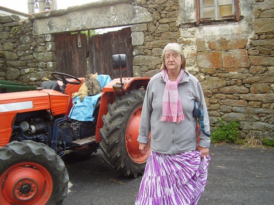 Fiona next to a tractor with cats in Galicia, Spain in 2011