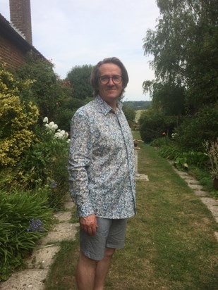 Andy (with lockdown hair) this summer, relaxing in his garden 