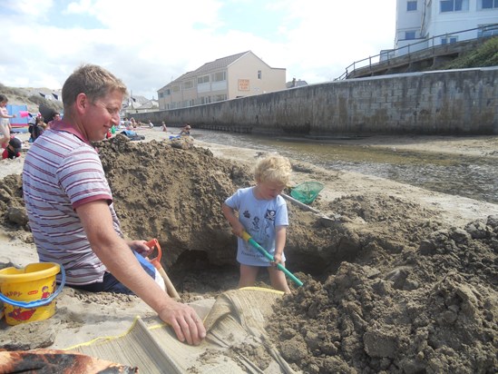 Jack digging a big hole on the beach with Daddy by the stream