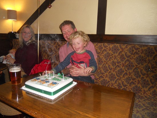 Jack with Daddy blowing his magic candles out on his minion cake at the Anchor