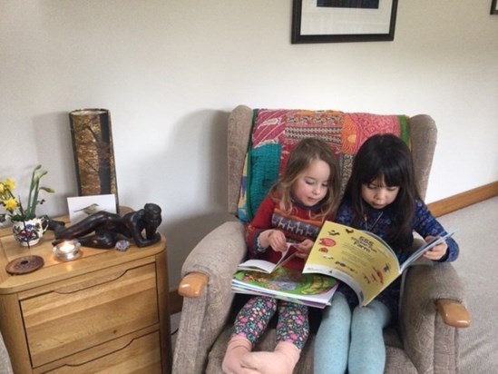 Bella and Iris reading in Bobbo's chair March 23 with her altar beside them